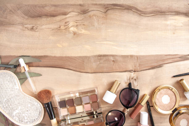 Kit of highlighters for makeup  with cosmetic brush on a wood background