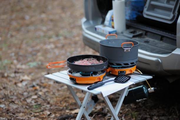 istock Cooking meat on camp stove in woods 1211055166