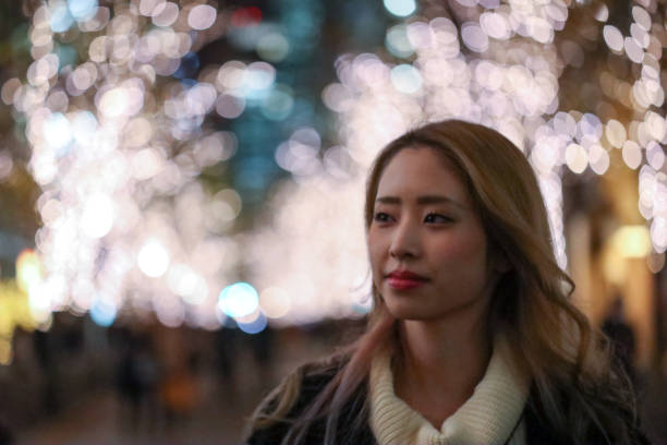 istock Young beautiful woman walking  in Christmas illuminations 1211058111