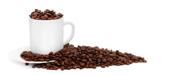 istock white coffee cup with saucer overfilled with roasted coffee beans isolated on white background with copy space, suitable for header or banner 1211066635