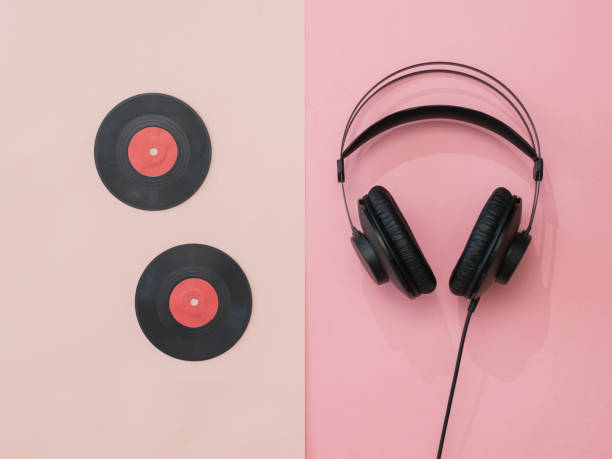 istock Two vinyl discs and headphones on a pink background. 1211067656