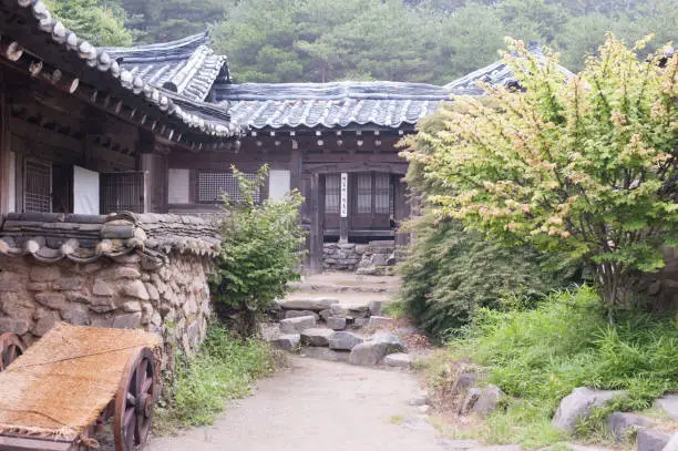 Stonewall Walkway with Traditional Korean Houses (a tile-roofed house, a house with a straw-thatched roof)