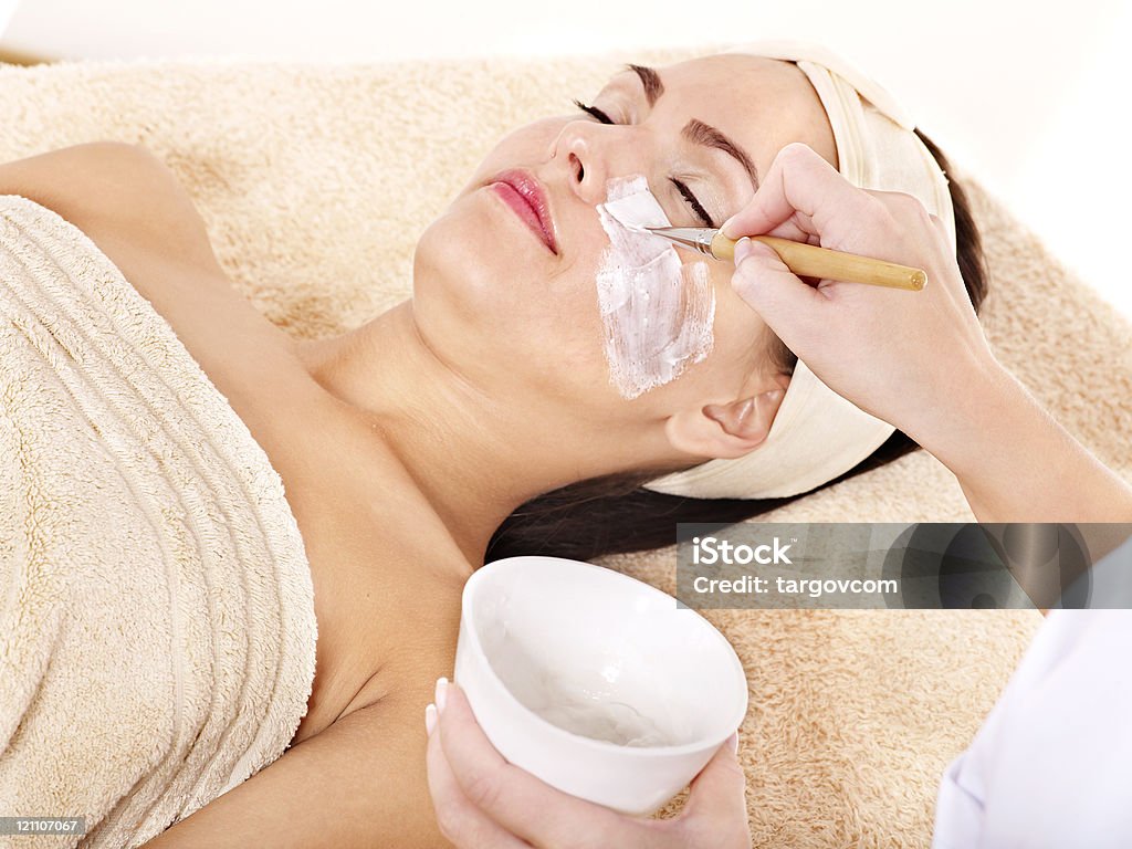 Estetista applicando una maschera viso per donna. - Foto stock royalty-free di Adulto