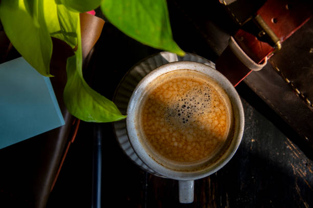 istock coffee break: briefcase and coffee on wooden table 1211075455