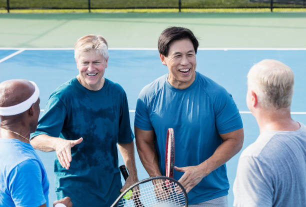 istock Men playing tennis, conversing at the net 1211078590