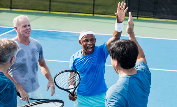 hombres jugando al tenis, alto-cinco - tennis senior adult adult mature adult fotografías e imágenes de stock