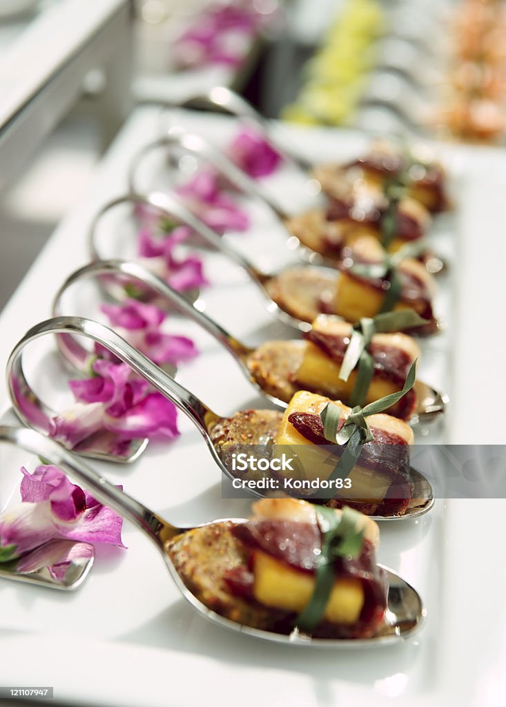 Canapes with cured ham on banquet table Canapes with cured ham (jamon or prosciutto) on banquet table, selective focus Arrangement Stock Photo