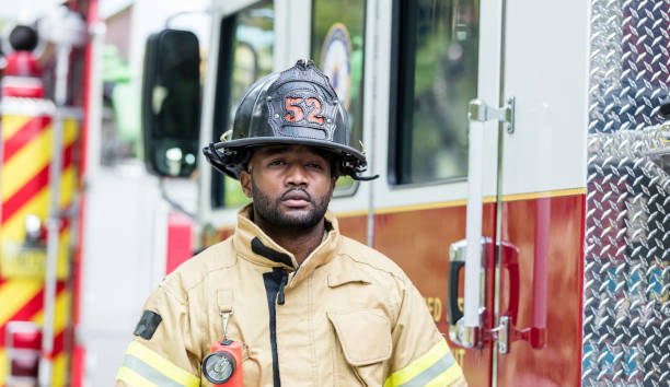 istock Firefighter in protective clothing outside fire truck 1211079612