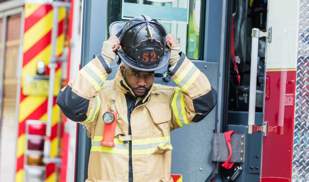 istock Firefighter putting on fire protection suit and helmet 1211079647
