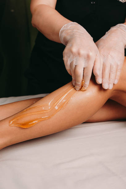 istock Sugaring procedure on legs done by a spa specialist during a procedure at the salon 1211080382