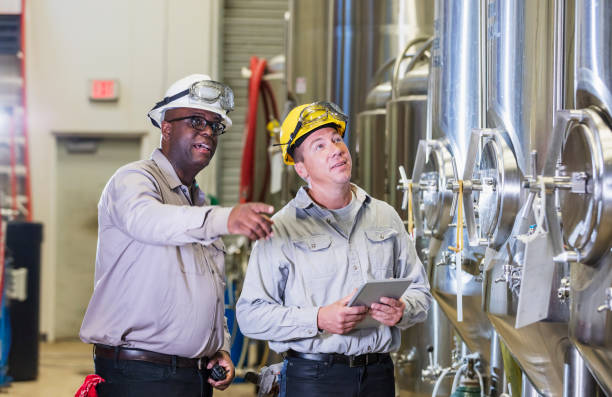 istock Two men working in factory, inspecting storage tank 1211080465