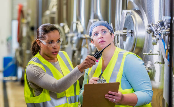 istock Two women working in factory, inspecting 1211080593