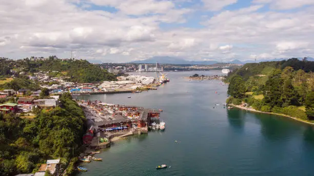 A drone aerial view of Puerto Montt city which appears Angelmo market and harbor at behind