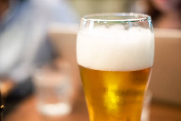 istock Long glass of fresh light beer with foam. Close up 1211094096