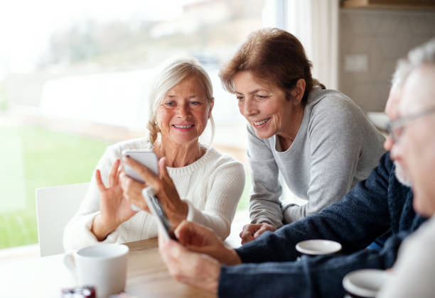 istock Group of senior friends at home, using smartphones. 1211096571