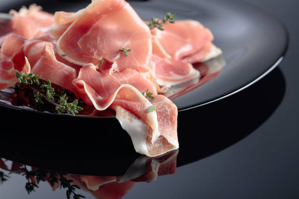 istock Prosciutto with thyme on a black plate. 1211096650