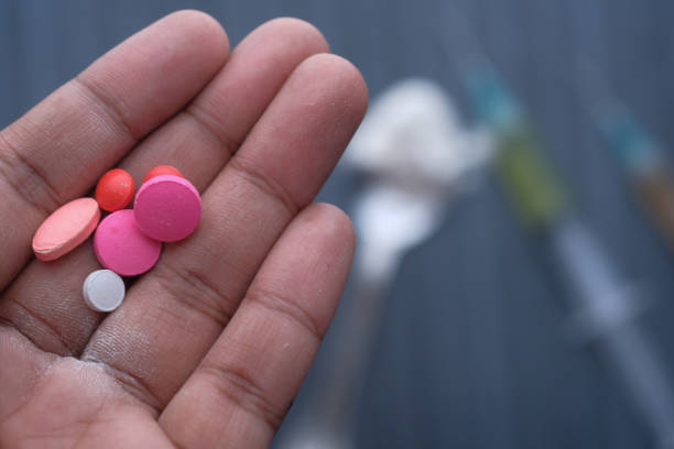 istock top view of pills on man hand and syringe on table 1211101703