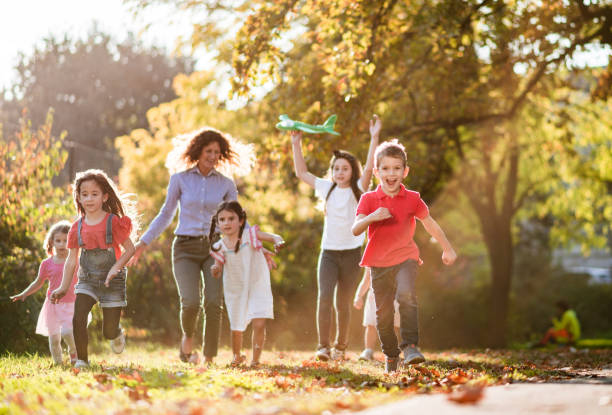 istock Happy kids running and playing in public park 1211103248