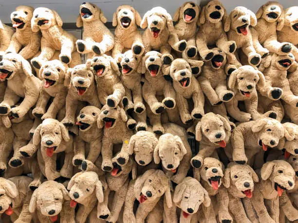 Brown dog dolls hang on to the wall for sales in kid depart at departmentstore.