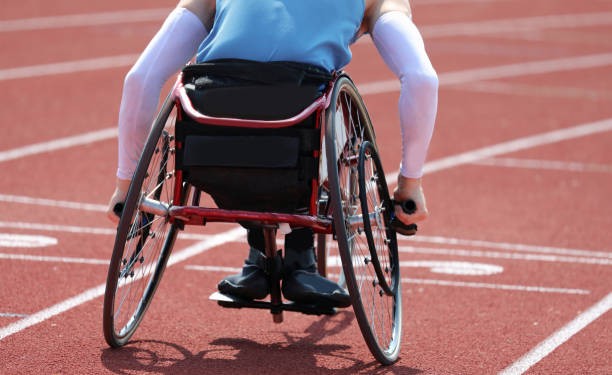 paralympics-athlet in einem rollstuhl mit lähmung in den beinen - tartanbahn stock-fotos und bilder