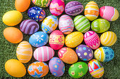 Happy Easter with colorful eggs at paintbrush for do it yourself on the grass with close up from top view