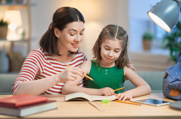 madre e figlie che si riuniscono - reading and writing classroom alphabet learning foto e immagini stock