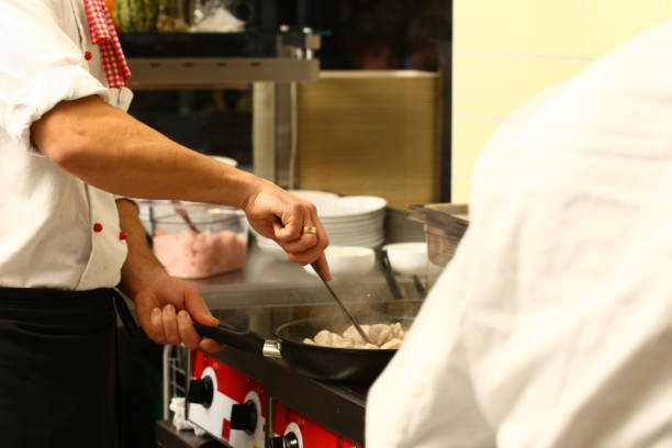 istock professional cook in kitchen preparing food for customers showing 1211109068