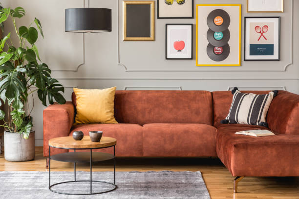 istock Elegant coffee table in front trendy sofa in modern living room interior with grey wall 1211109319