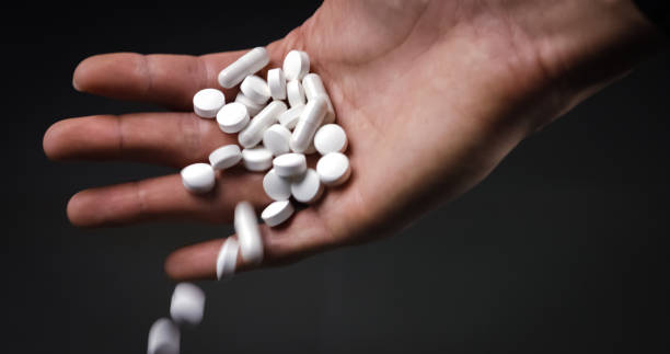 istock Holding many white drug pills 1211114371