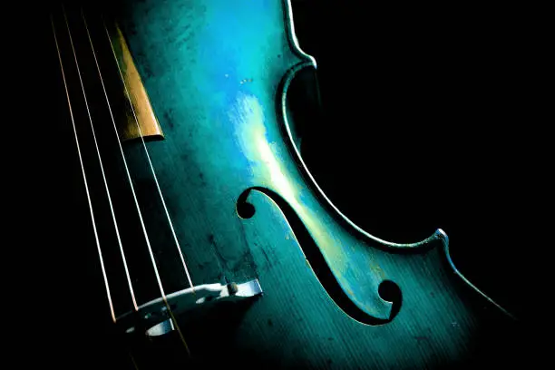 Photo of Cello in aqua menthe on dark background.