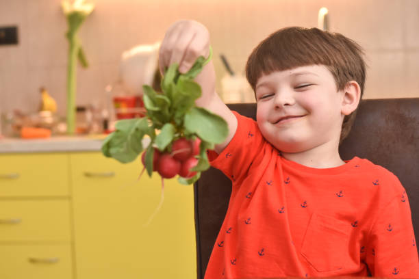 istock Six year old boy hold organic radish 1211116576