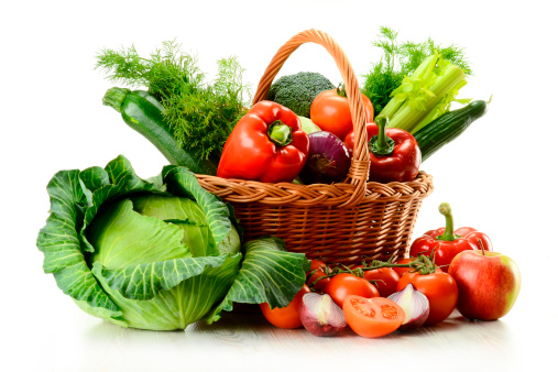 Composition with raw vegetables and wicker basket isolated on white