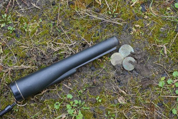 istock one black pinpointer lies at old coins on green moss 1211118657