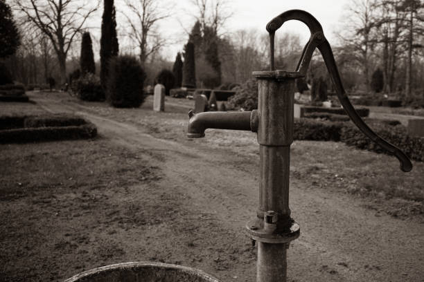 an old cast-iron water pump stands on a cemetery