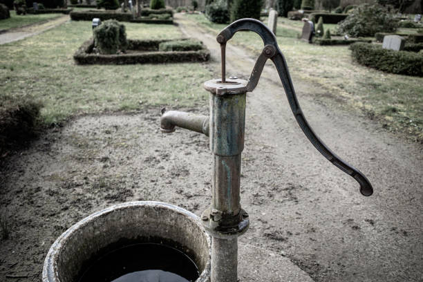 an old cast-iron water pump stands on a cemetery