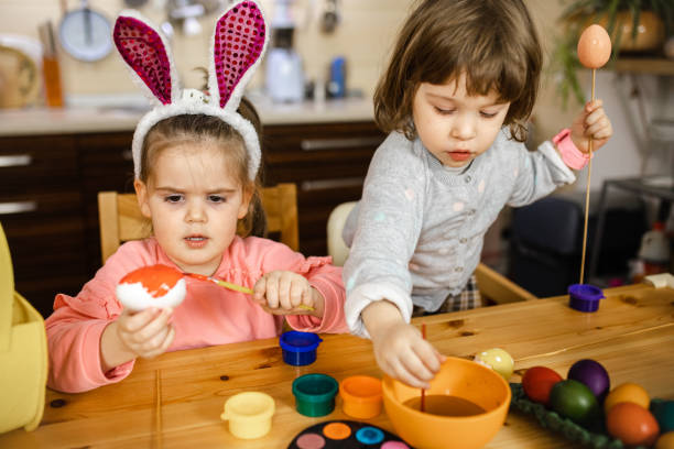 istock She is so concentrated to precise paint her easter egg in orange color 1211124704