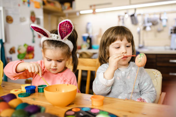 istock Adorable sisters are so concentrated into Easter egg decorating 1211126841