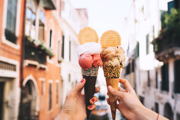 bellissimo e delizioso gelato italiano in cono di waffle di fronte a strade e ponti di venezia. - italian dessert foto e immagini stock