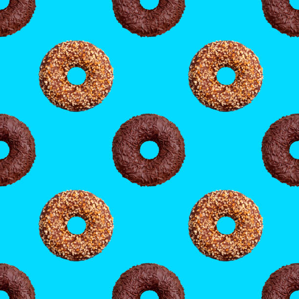 istock Seamless pattern of chocolate and nut donuts on blue background isolated top view, colorful donut repeating ornament, bagels wallpaper, sweet cakes texture, dessert trendy print, biscuit art backdrop 1211132876