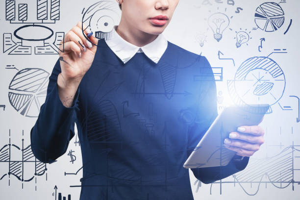istock Woman with tablet drawing business plan sketch 1211142692