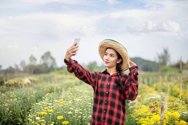 mujer en el campo de flores de la naturaleza - scented asia asian culture bunch fotografías e imágenes de stock