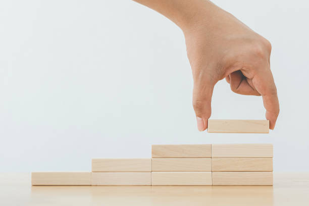 istock Hand arranging wood block stacking as step stair. Ladder career path concept for business growth success process 1211146191