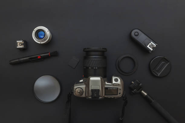 istock Photographer workplace with dslr camera system, camera cleaning kit, lens and camera accessory on dark black table background. Hobby travel photography concept. Flat lay top view copy space 1211149900