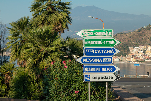 The road sign under Mount Etna shows the directions to Catania, Messina and Giardini Naxos