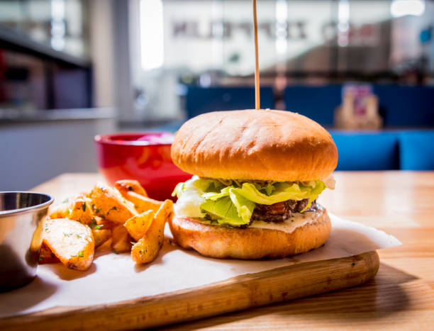 istock Tasty cheeseburger and chips on the wooden table. Restaurant. 1211151381