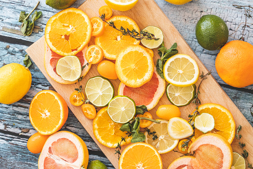 Slices of fresh citrus fruit on wooden cutting board