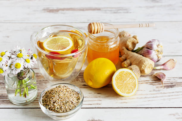 cup of tea with chamomile, lemon, ginger and honey on white wooden table. alternanive medicine concept. - ginger tea cup cold and flu tea imagens e fotografias de stock