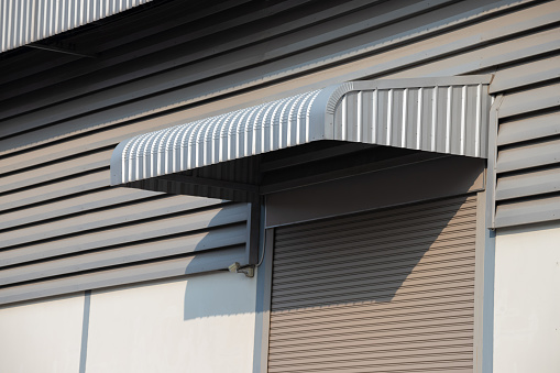 silver metal awning over shutter steel door of factory, steel awning.