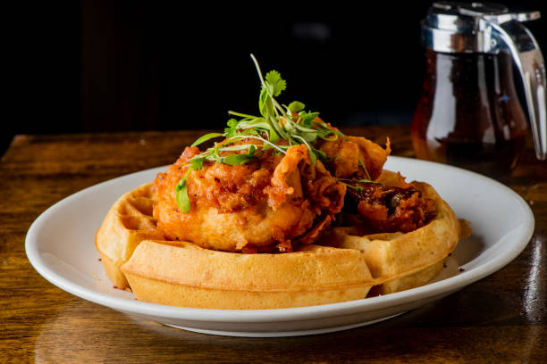 pollo y gofres. gofres caseros con pollo frito del sur crujiente, mantequilla y jarabe de arce. desayuno americano clásico o brunch favorito. gofres hechos a partir de rasguños servidos con mantequilla y jarabe de arce. - waffle chicken fried chicken food fotografías e imágenes de stock