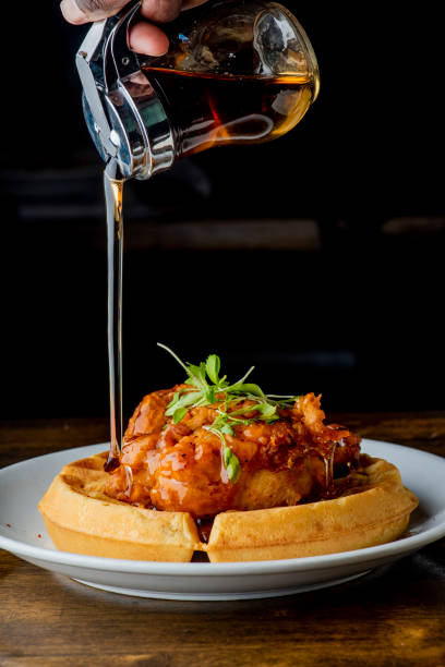 istock Chicken and waffles. Homemade waffles with crispy southern fried chicken, butter and maple syrup. Classic American breakfast or brunch favorite. Made from scratch waffles served with butter and maple syrup. 1211158043